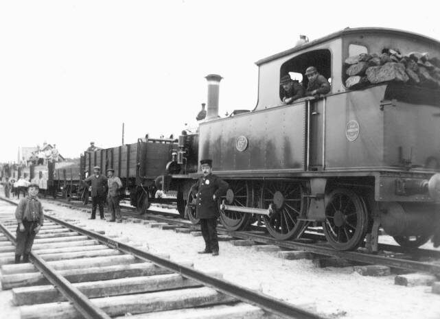 Anjum 1913 met loc NFLS-1057. Een echte nieuwsfoto in die tijd, omdat hier de aanleg van het laatste stuk tussen Metslawier en Anjum op de gevoelige plaat werd vastgelegd. De komst van de fotograaf was in die tijd iets heel bijzonders. Het werk werd even gestaakt en iedereen ging er eens even echt voor staan. Fotograaf Jacob Mosselman, Stichting Fotografie Willem Kamminga, Dokkum. Verzameling: Wietze Hoekstra.