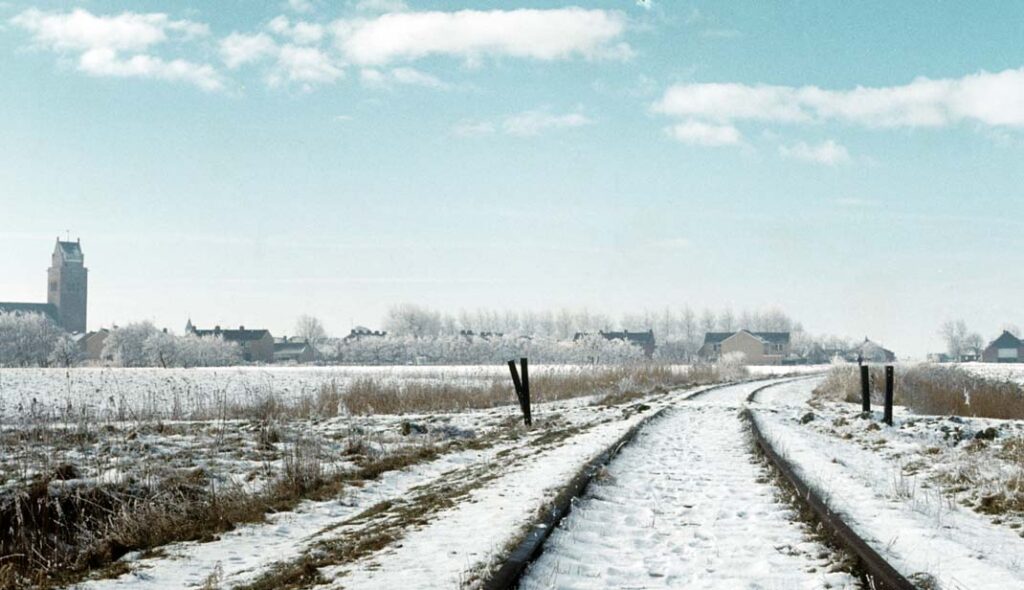 Sneeuwopname van het al jaren niet meer bereden spoor Stiens - Minnertsga met links de kerktoren van Minnertsga in februari 1975. Foto: Wietse Hoekstra.